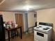 Modest kitchen area features an electric range, small table, and essential appliances at 730 Druid St, Lakeland, FL 33805