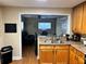 View of a spacious kitchen with bright wooden cabinets and a connecting opening to the living room at 730 Druid St, Lakeland, FL 33805