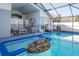 Sparkling pool with screened enclosure, featuring a rock waterfall spa and outdoor seating area at 8001 Arrow Creek Rd, Kissimmee, FL 34747