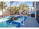 Inviting pool area featuring a spa, sun loungers, and a screened enclosure for privacy and relaxation at 8001 Arrow Creek Rd, Kissimmee, FL 34747