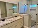 Modern bathroom with double sinks, a large mirror, and a frameless glass shower at 806 Avenue G Ne, Winter Haven, FL 33881