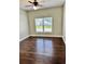 Bedroom with wood floors, ceiling fan, and large window creating a serene space at 806 Avenue G Ne, Winter Haven, FL 33881