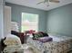 Bedroom featuring blue accent wall, ceiling fan, and tile flooring for a cozy vibe at 9430 Daney St, Gotha, FL 34734
