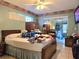 Main bedroom with ceiling fan, en-suite sliding doors to lanai, and tile floors at 9430 Daney St, Gotha, FL 34734