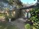Charming back patio with a cozy outdoor dining set, lush landscaping, and verdant green lawns at 104 Woden Way, Winter Haven, FL 33884