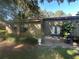 Charming back patio with a cozy outdoor dining set, lush landscaping, and verdant green lawns at 104 Woden Way, Winter Haven, FL 33884