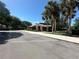 Community building with covered walkway, surrounded by lush landscaping and ample parking at 104 Woden Way, Winter Haven, FL 33884