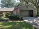 Charming single story home featuring a tile roof, brick veneer, and a two-car garage at 104 Woden Way, Winter Haven, FL 33884