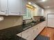 Stylish kitchen featuring black countertops, white cabinetry, and a view of the backyard at 104 Woden Way, Winter Haven, FL 33884