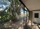 Screened lanai featuring views of lush plants and an entry door with decorative window at 104 Woden Way, Winter Haven, FL 33884