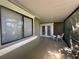 Screened porch with neutral paint, white trim and furniture, and double glass doors at 104 Woden Way, Winter Haven, FL 33884