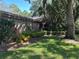 Lush landscaping and mature trees adorn the side yard of this charming brick home at 104 Woden Way, Winter Haven, FL 33884