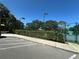 Tennis court with green fence and bushes, with parking nearby at 104 Woden Way, Winter Haven, FL 33884
