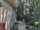 Brick home featuring a side walkway lush with greenery and manicured landscaping at 104 Woden Way, Winter Haven, FL 33884