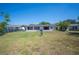 Large grassy backyard featuring a spacious area for outdoor activities and a clear view of the home's rear facade at 109 Pasco Se Rd, Winter Haven, FL 33884
