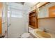 Compact bathroom features a tiled shower, matching sink and toilet, and a small wooden shelf at 109 Pasco Se Rd, Winter Haven, FL 33884