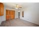 Bedroom with wood-look floors, closet, ceiling fan, and doorway to additional rooms at 109 Pasco Se Rd, Winter Haven, FL 33884