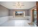 Spacious living room with white floors and views of the backyard through the secure window at 109 Pasco Se Rd, Winter Haven, FL 33884