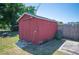 Exterior shot of the red storage shed in the backyard, offering ample space for storing tools and equipment at 109 Pasco Se Rd, Winter Haven, FL 33884