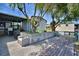 Backyard with a small deck, patio, a bench and a chair with mature trees at 117 Bream St, Haines City, FL 33844