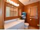 Bathroom featuring wood paneling, white vanity, walk-in shower, mirrored medicine cabinet, and tile flooring at 117 Bream St, Haines City, FL 33844
