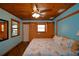 Cozy bedroom with a decorative ceiling fan, unique wooden ceiling and a large bed with stylish marine-themed comforter at 117 Bream St, Haines City, FL 33844