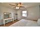Bedroom with ceiling fan, wood-look flooring, and dresser with mirror, providing a relaxing retreat at 117 Bream St, Haines City, FL 33844