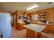 Spacious kitchen with wood cabinets, stainless steel appliances, a kitchen island, and a serving counter at 117 Bream St, Haines City, FL 33844