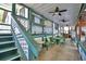 View of a covered patio area with ample seating, steps to the yard, and a ceiling fan for added comfort at 117 Bream St, Haines City, FL 33844