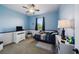 Light blue bedroom with ceiling fan, dresser with TV, and -friendly decor at 132 Dinner Lake Ave, Lake Wales, FL 33859