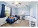 Blue and white bedroom with large window, ceiling fan, and shelves with toy storage at 132 Dinner Lake Ave, Lake Wales, FL 33859