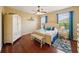 Inviting bedroom with warm tones, hardwood floors, ceiling fan, and matching furniture at 132 Dinner Lake Ave, Lake Wales, FL 33859