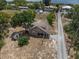 Aerial view of a brown home, shed, and treed landscape near a lake at 134 Masterpiece Rd, Lake Wales, FL 33898