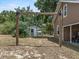 Backyard with a swing, shed, lawn equipment, and trees at 134 Masterpiece Rd, Lake Wales, FL 33898