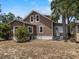Exterior view of a two-story home featuring yard, architectural details, and a side door at 134 Masterpiece Rd, Lake Wales, FL 33898