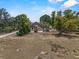 Exterior aerial view of a brown house with a shed in a treed lot at 134 Masterpiece Rd, Lake Wales, FL 33898