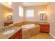 Large bathroom featuring a garden tub, dual vanities, and tile accents at 135 Eloise Oaks Dr, Winter Haven, FL 33884