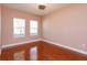 Cozy bedroom featuring hardwood floors, two windows, and a ceiling fan at 135 Eloise Oaks Dr, Winter Haven, FL 33884