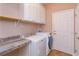 Convenient laundry room includes washer, dryer, countertop space, and extra cabinet storage at 135 Eloise Oaks Dr, Winter Haven, FL 33884