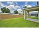 Home's covered patio with a view to a screen enclosed pool and fenced yard at 154 Canna Dr, Davenport, FL 33897