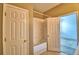 Well-lit bathroom features a tub with a shower and a door to the bedroom for easy accessibility at 154 Canna Dr, Davenport, FL 33897