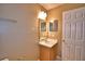 Neutral bathroom with a single sink vanity and a large mirror at 154 Canna Dr, Davenport, FL 33897