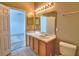 Bright bathroom with a single sink vanity, a large mirror, and a toilet offering a functional space at 154 Canna Dr, Davenport, FL 33897
