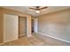 Bedroom with a ceiling fan, neutral carpet, and a closet with white doors at 154 Canna Dr, Davenport, FL 33897