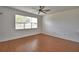 Cozy bedroom featuring a ceiling fan, window with blinds, and laminate floors at 154 Canna Dr, Davenport, FL 33897