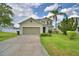 Inviting two-story home features a lush lawn and a convenient two-car garage in a residential area at 154 Canna Dr, Davenport, FL 33897