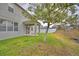 Backyard view highlights covered patio, grassy area, and mature tree at 154 Canna Dr, Davenport, FL 33897