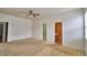 Open main bedroom with ceiling fan, neutral carpeting, and bathroom at 154 Canna Dr, Davenport, FL 33897