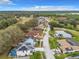 An aerial view displays a neighborhood with a house featuring solar panels and an enclosed pool at 157 Golf Aire Blvd, Haines City, FL 33844