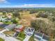 Expansive aerial view of the home showcasing lush greenery and serene ponds in the surrounding neighborhood at 157 Golf Aire Blvd, Haines City, FL 33844